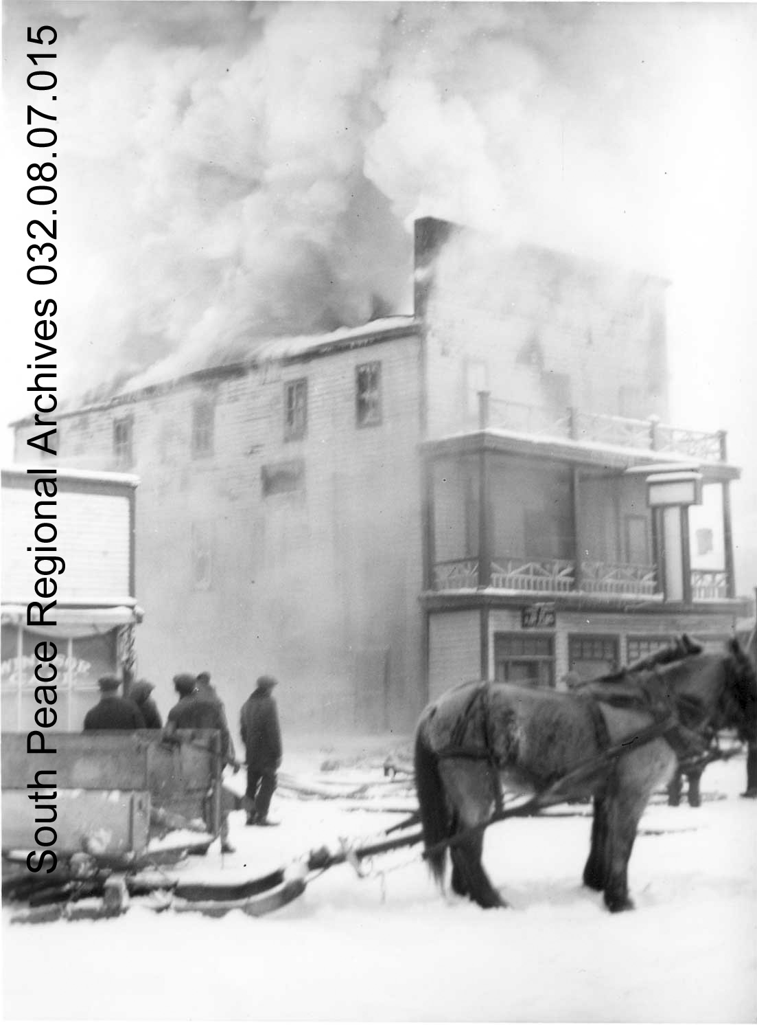 SPRA 0032.08.07.15: Corona Hotel. Early stages of the fire, taken from the street in front of the hotel. Horses, sleigh and men in foreground, February 1936. 